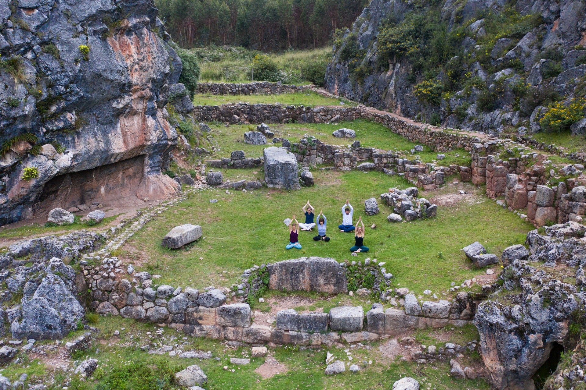 Travelers practicing yoga in the Peruvian Andes surrounded by mountains.